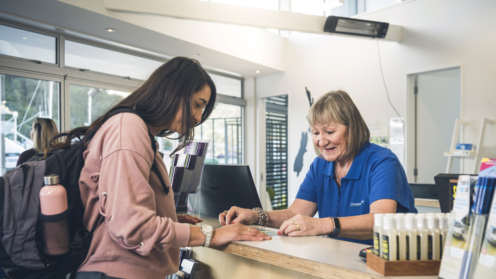 A passenger talks to a staff member at the Cougar Line office and information desk in Picton at the Marlborough Sounds, New Zealand.