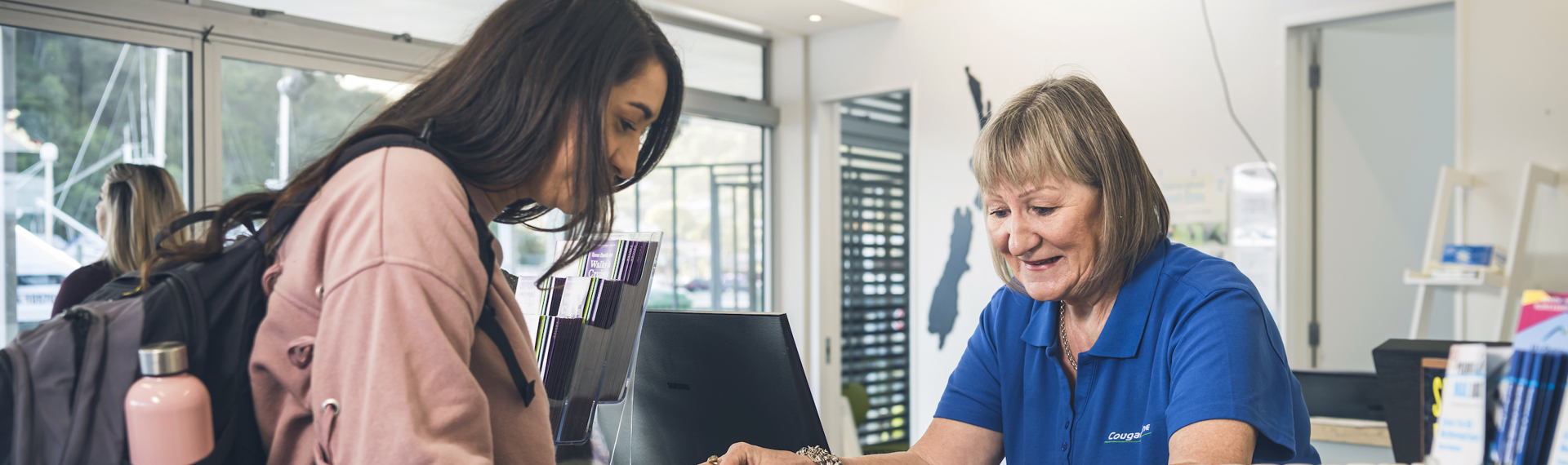 A passenger talks to a staff member at the Cougar Line office and information desk in Picton at the Marlborough Sounds, New Zealand.