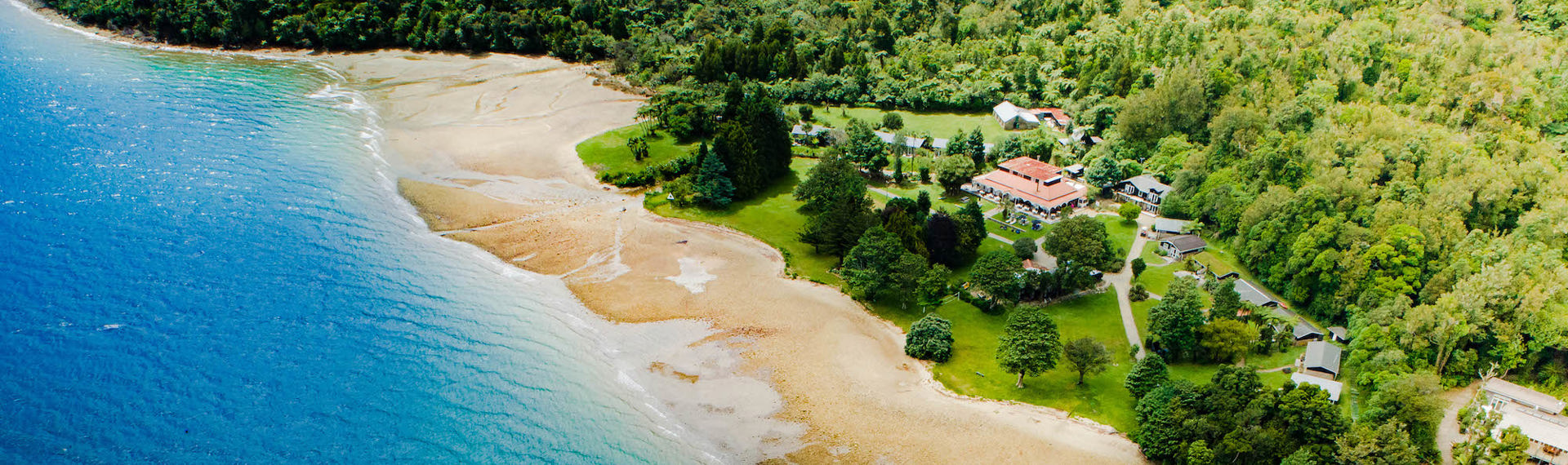 Aerial view of Furneaux Lodge across Endeavour Inlet and the jetty in the Marlborough Sounds, at the top of New Zealand's South Island.