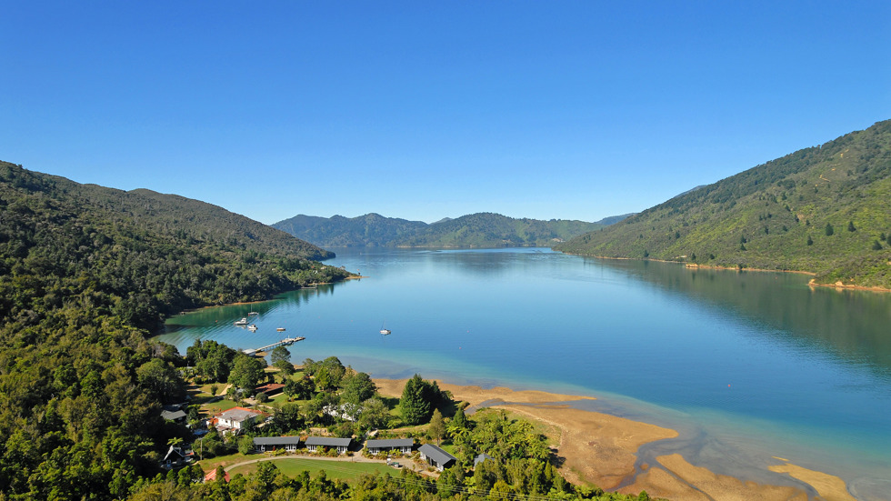 An aerial view of Endeavour Inlet, with Furneaux Lodge in the foreground, in the outer Queen Charlotte Sound/Tōtaranui, Marlborough Sounds, New Zealand.