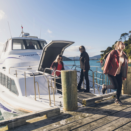 Cougar Line passengers disembark the boat at Ship Cove/Meretoto to start the Queen Charlotte Track in the Marlborough Sounds, New Zealand.